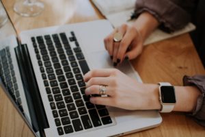 hands of woman typing on apple macbook